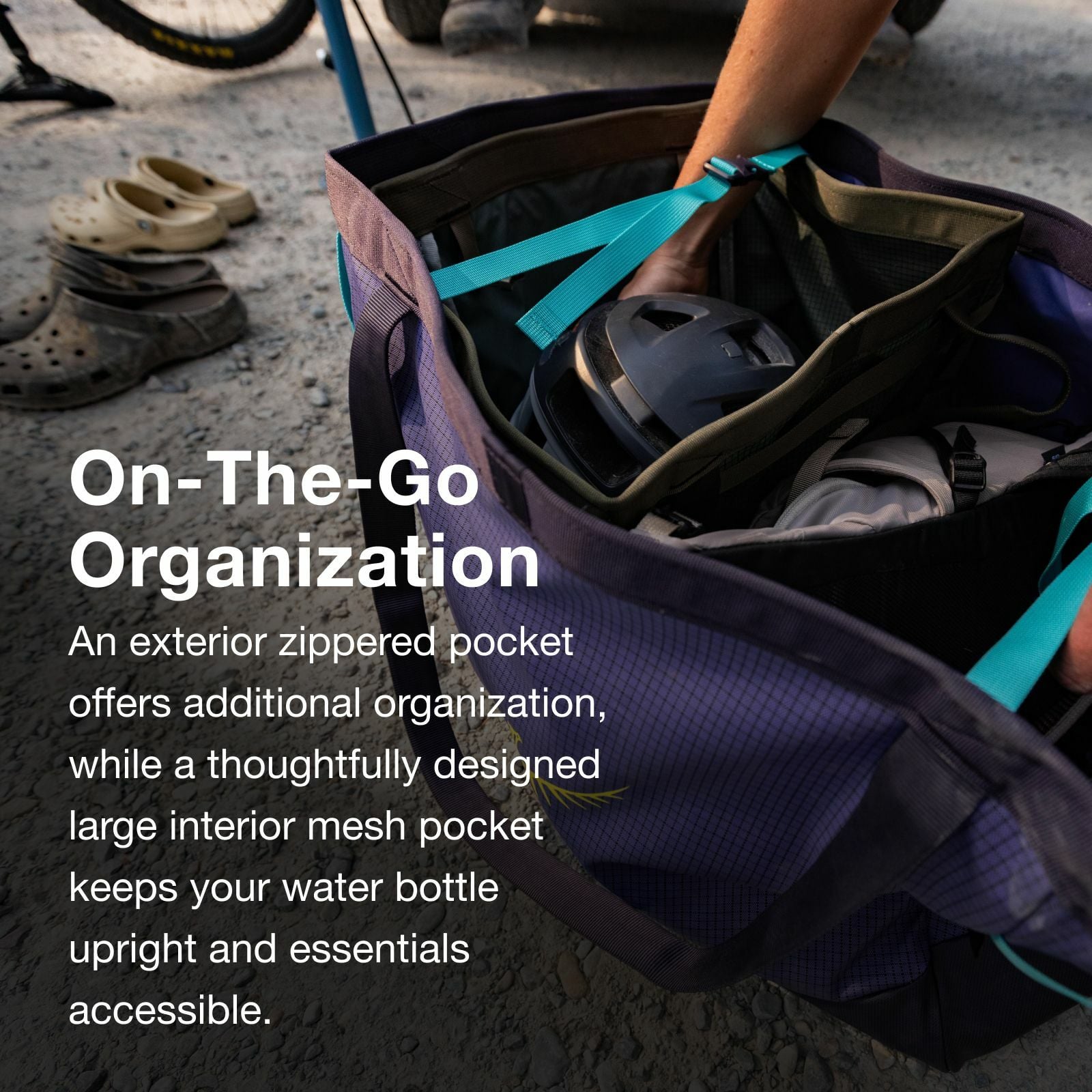 A hand reaches into a spacious bag with a zippered pocket, revealing a water bottle and gear, emphasizing on-the-go organization.