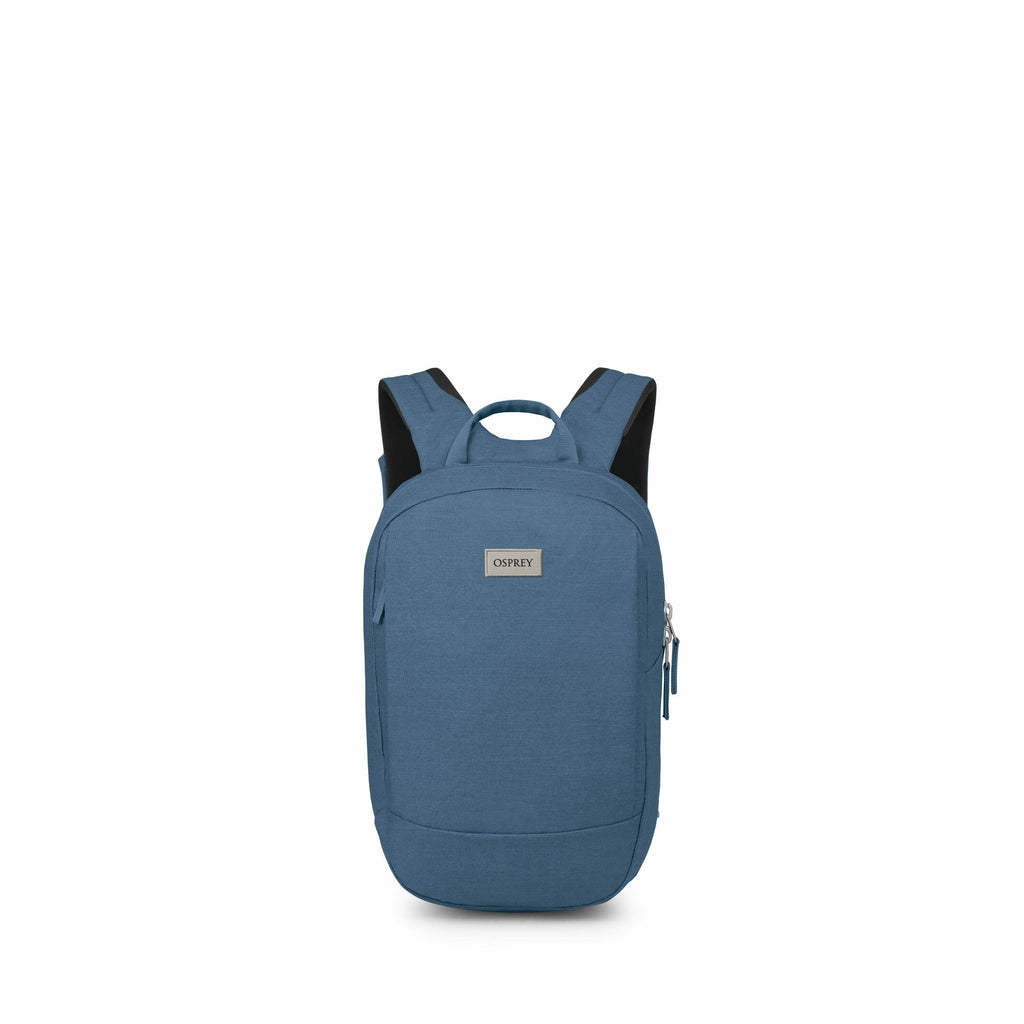 The image features a blue Osprey backpack positioned upright against a plain white background. The backpack has a sleek, minimalist design with a single main compartment and a front zippered pocket. On the front of the backpack, there is a rectangular lab