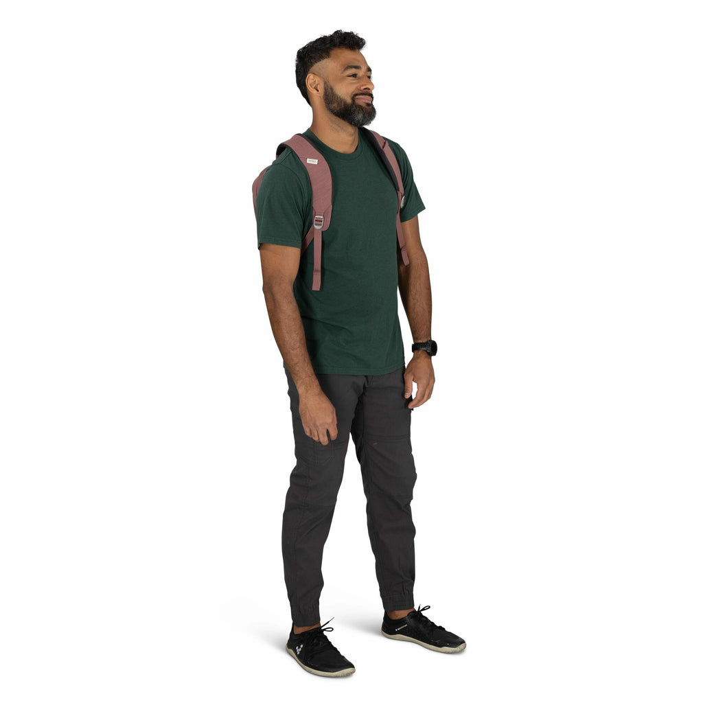 The image shows a person wearing casual attire suitable for outdoor activities. They are dressed in a dark green t-shirt paired with charcoal gray pants that have elasticized cuffs, offering both style and comfort. The person is accessorized with a watch