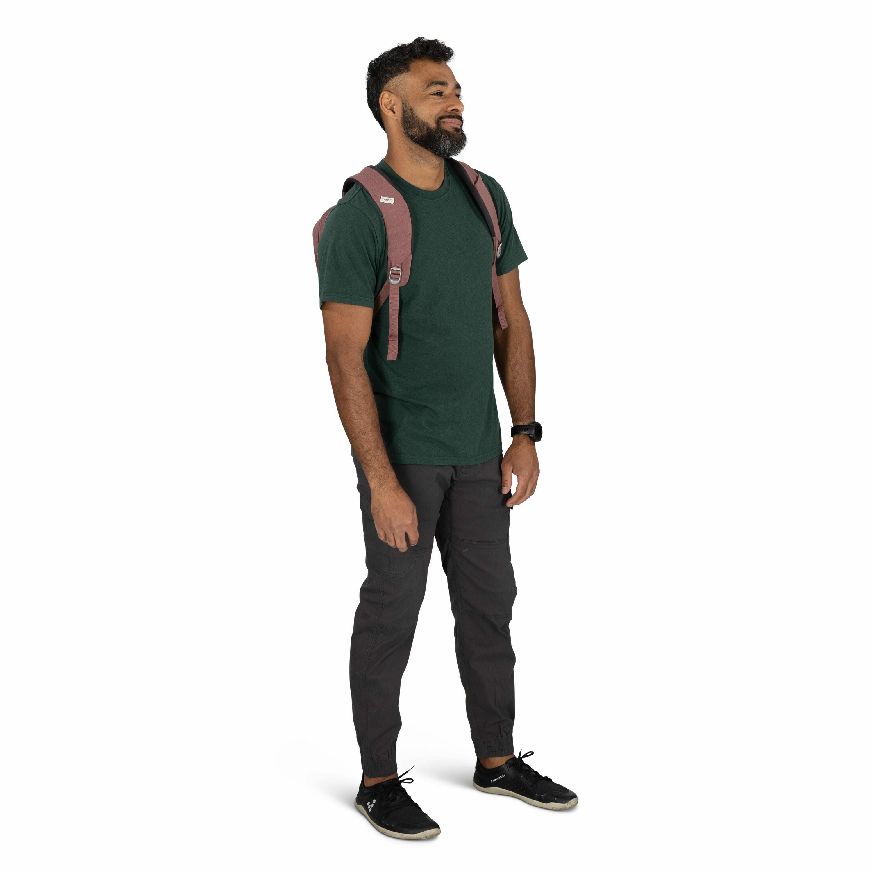 The image shows a person wearing casual attire suitable for outdoor activities. They are dressed in a dark green t-shirt paired with charcoal gray pants that have elasticized cuffs, offering both style and comfort. The person is accessorized with a watch