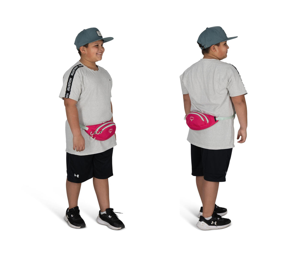 The image shows a young person standing, depicted in both a front and back view. They are wearing a light gray T-shirt with black stripes on the shoulders and black athletic shorts. A pink fanny pack is strapped around their waist. Their outfit is complet