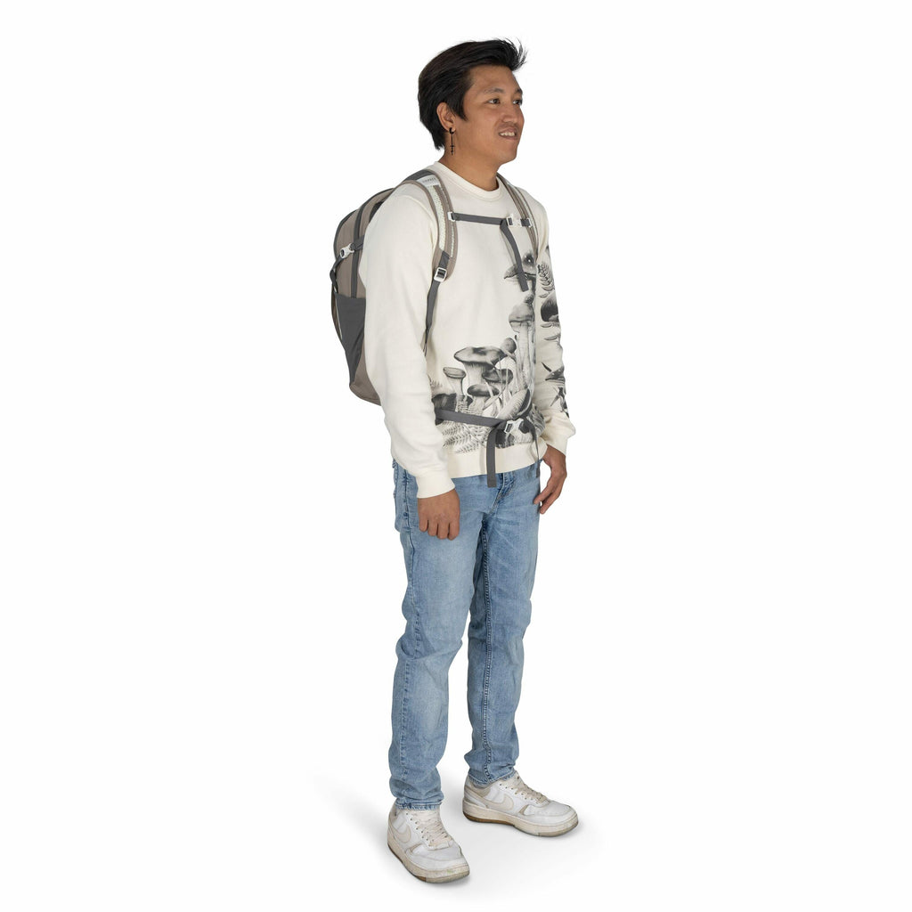 The image shows a person standing in a relaxed posture, wearing a casual outfit. They are dressed in a white sweatshirt featuring a black and white mushroom print design. The person is also wearing light blue jeans and white sneakers. Over their shoulders