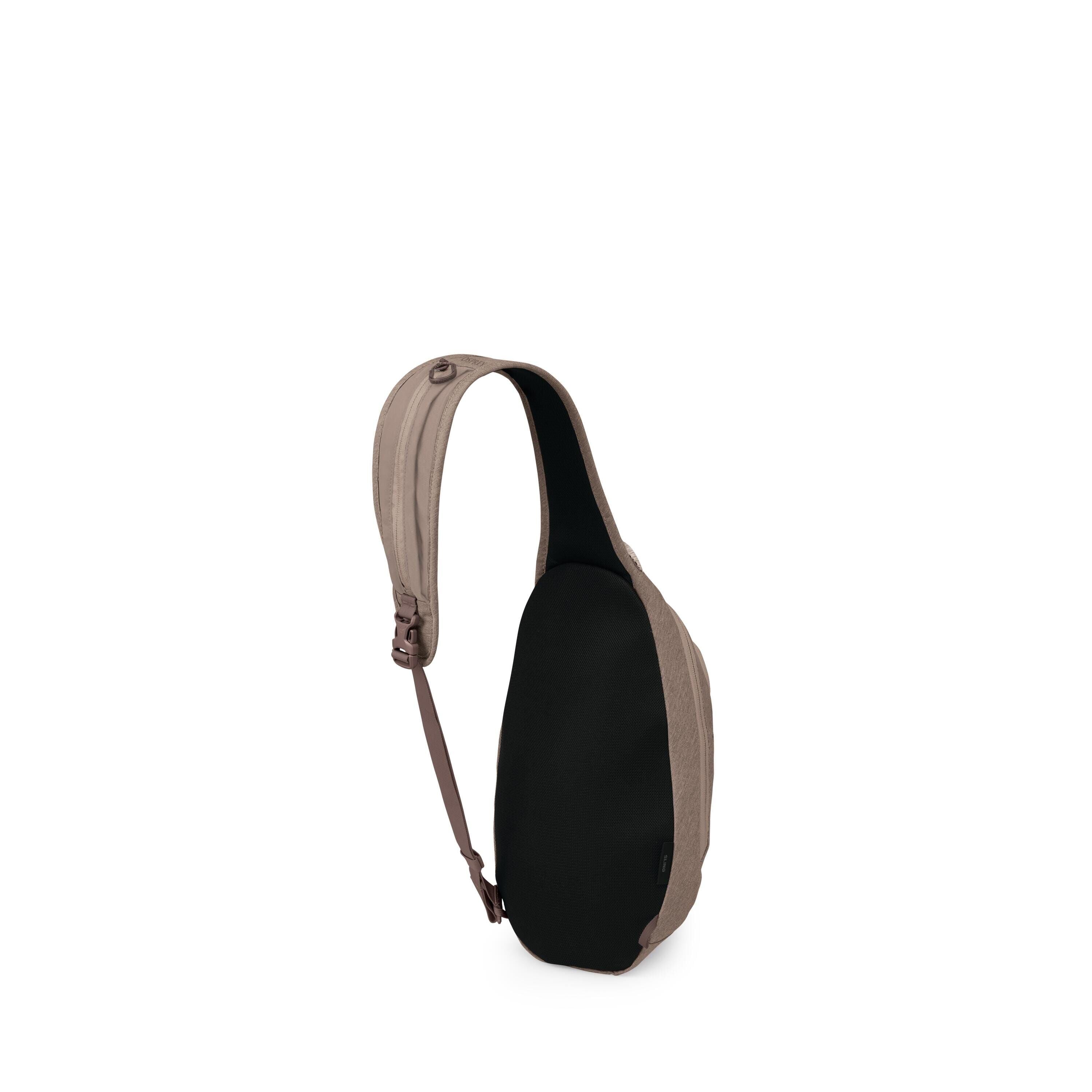 The image shows a compact sling backpack with a teardrop-shaped body. It has a single padded shoulder strap in taupe that curves over the top and connects to an adjustable brown webbing strap. The back panel is black and appears cushioned for comfort. The