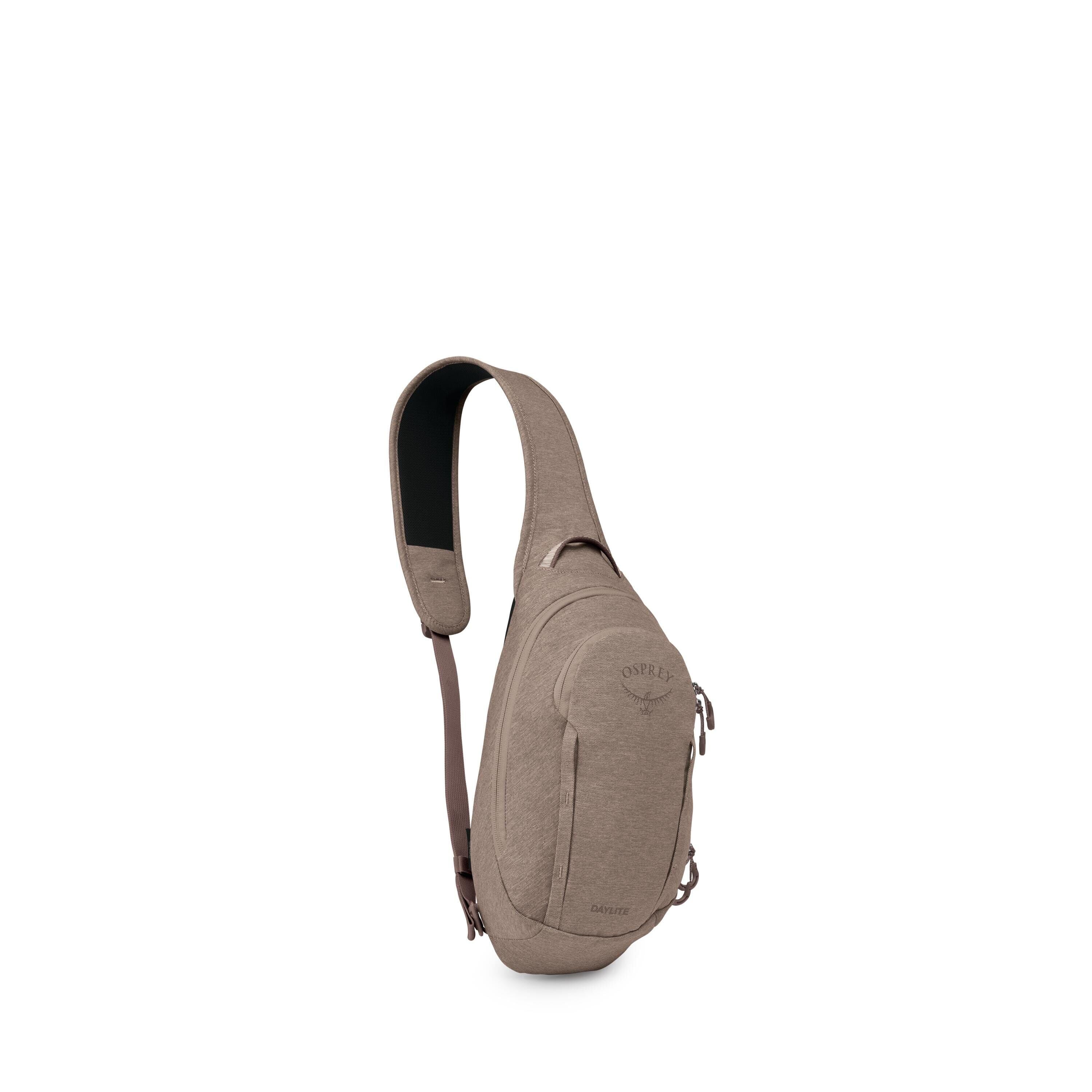 The image shows a compact, tan-colored sling bag with a single padded shoulder strap. Its teardrop-shaped body has multiple zippered compartments and subtle seam detailing. The front features an Osprey logo patch and the word "Daylite" near the bottom. Th