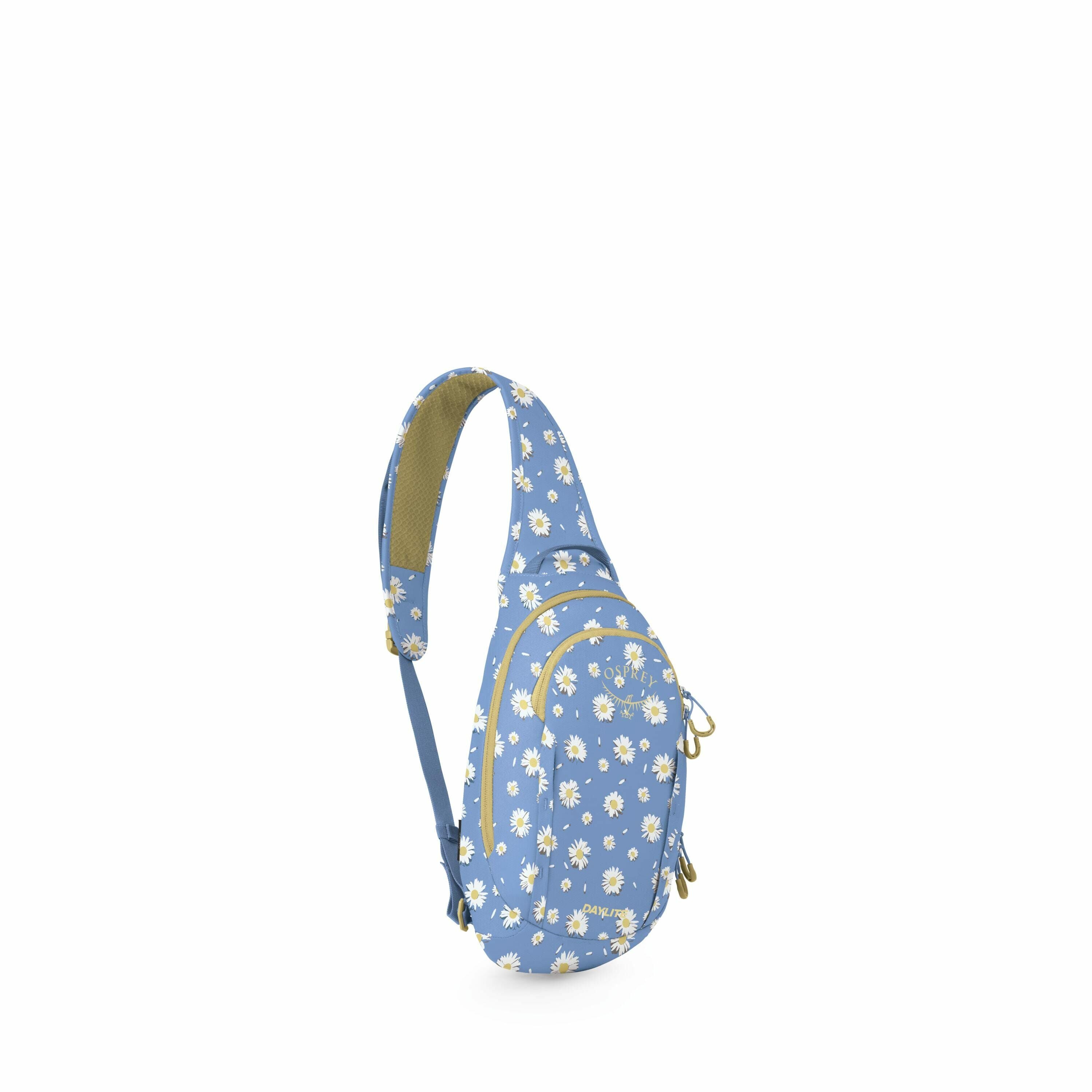 The image sequence shows a blue sling backpack with a pattern of white and yellow daisies on it. The backpack is designed with multiple zippered compartments for storage. It features a single shoulder strap, also adorned with the daisy pattern, and appear