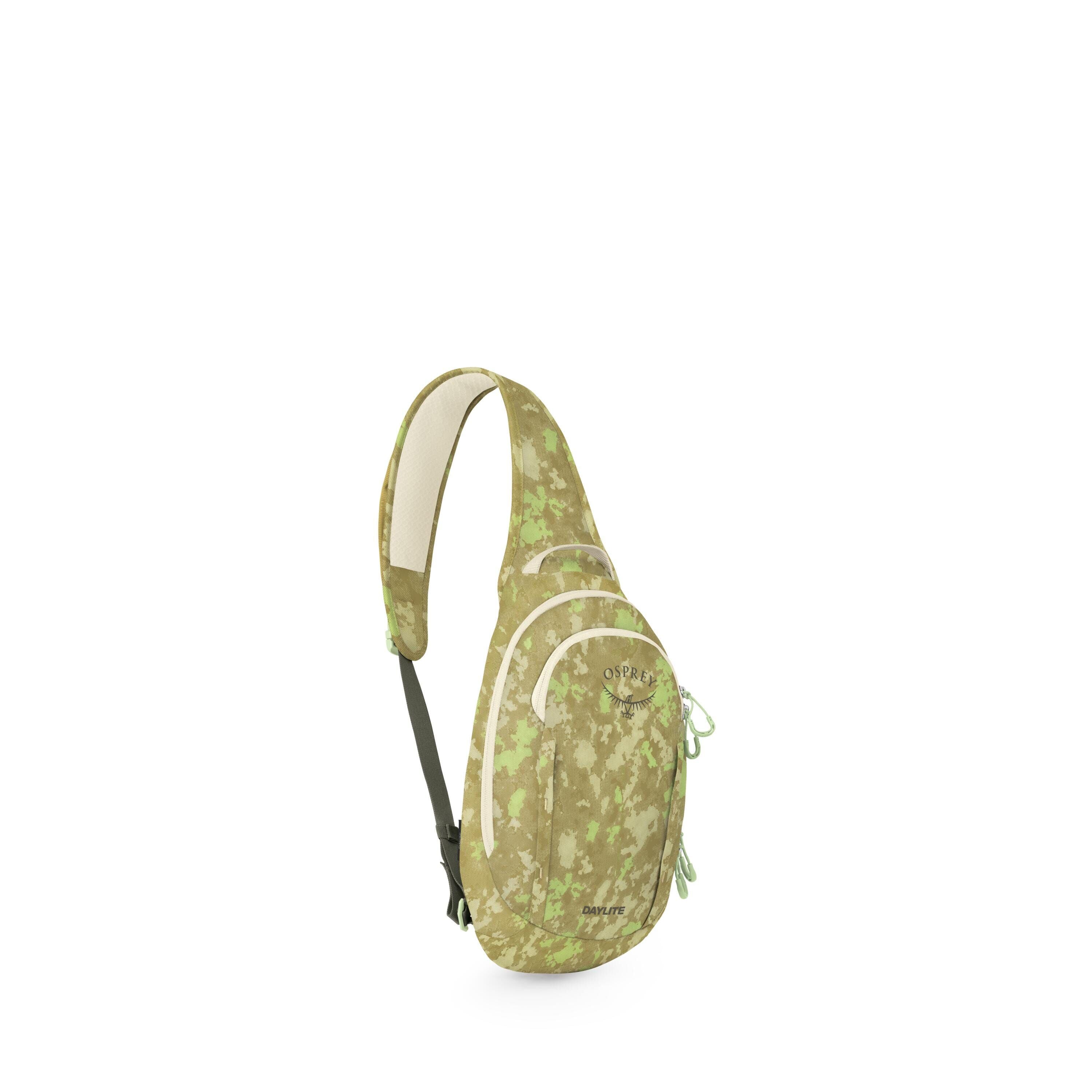 The images show a green camo-patterned sling bag displayed against a white background. It has a single padded shoulder strap, a curved teardrop shape, and two front zippered compartments with contrasting light trim. The Osprey logo and the word "Daylite"