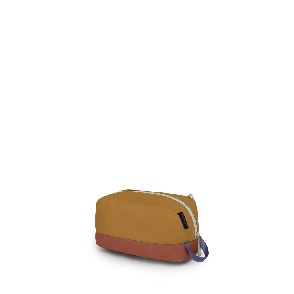 A small, rectangular toiletry or accessory pouch sits against a white backdrop. It has a mustard-yellow body with a brick-red base and a mint-green zipper running along the top. A short carry loop in blue with a light green accent is attached at one end.