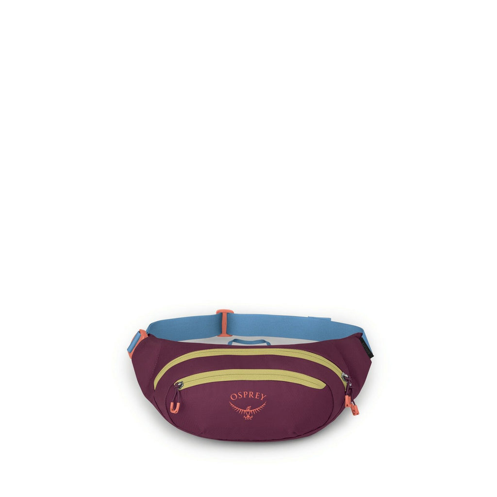 The image shows a small waist pack designed by Osprey, primarily in a burgundy color. It features a front zipper compartment highlighted by a contrasting orange zipper and a lighter green strip across the front. The back of the pack has a light blue waist