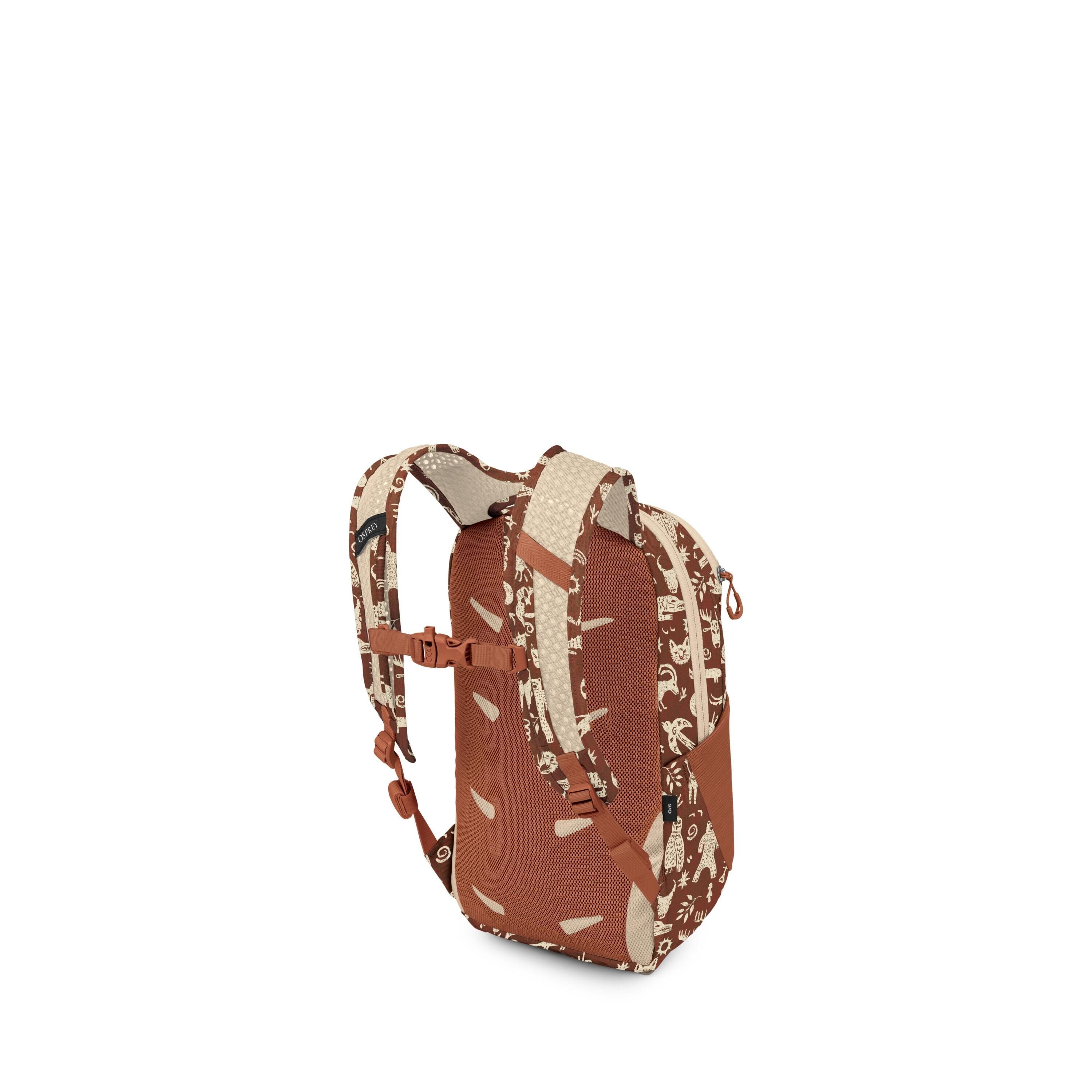 A small backpack is shown from a rear three-quarter view, highlighting its straps and padded back panel. The bag is primarily rust-brown with beige accents and a playful cream-colored pattern featuring animals and shapes along the straps and sides. It has