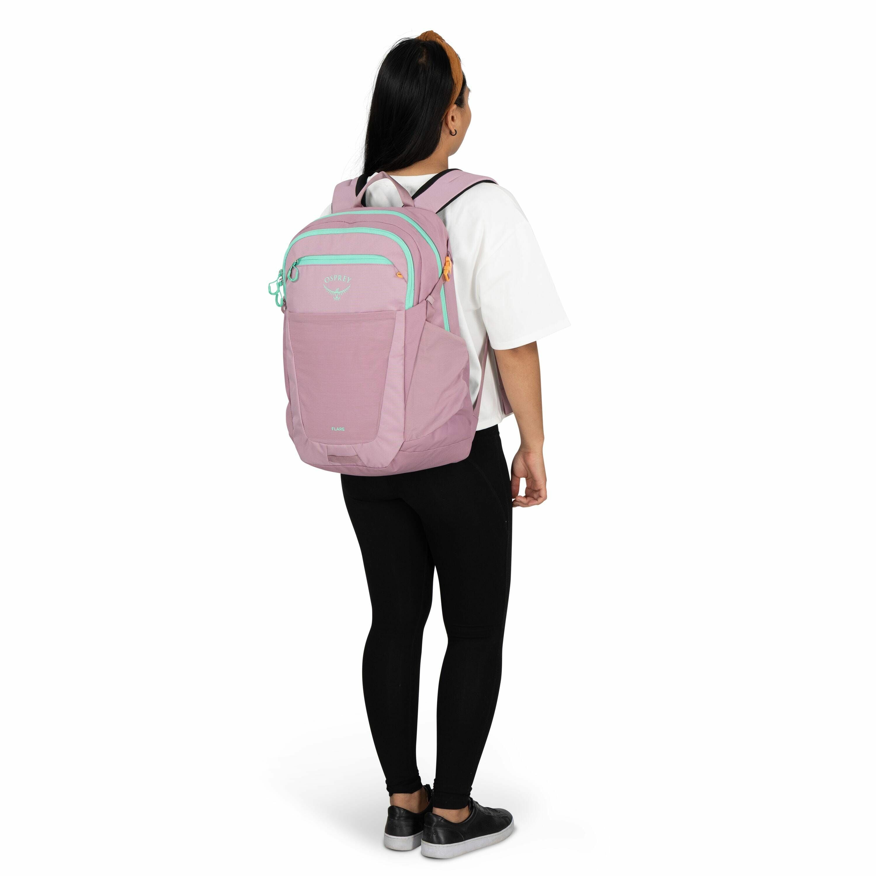 The image features a person standing in a profile view, wearing a large Osprey backpack. The backpack is predominantly light purple with aqua-colored zippers and accents, and features the Osprey logo and the word "Flare" visible on it. The person is weari