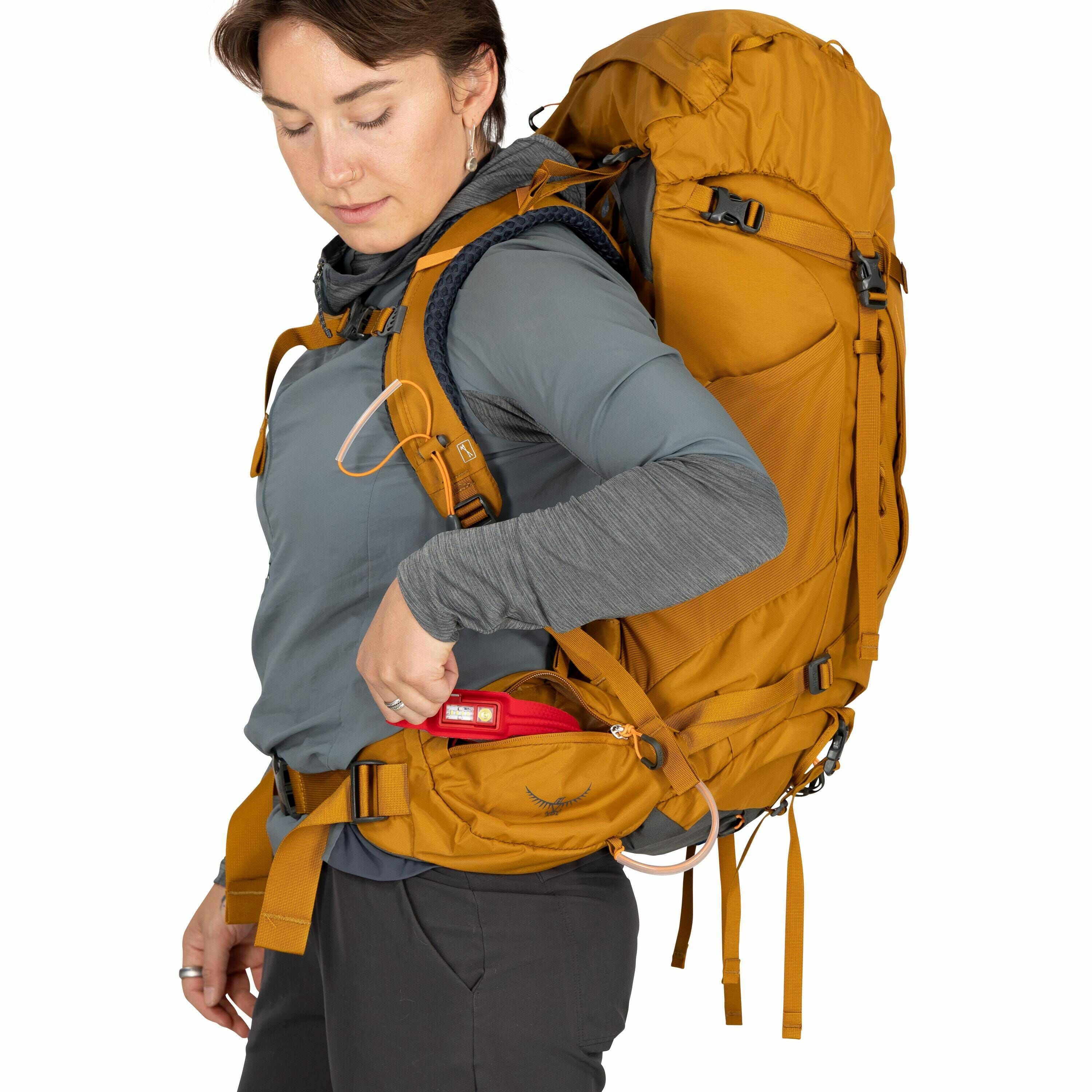 The image features a person wearing a large yellow backpack, which appears to be designed for hiking or outdoor activities. The backpack includes several compartments and adjustable straps for secure and comfortable carrying. The individual is dressed in