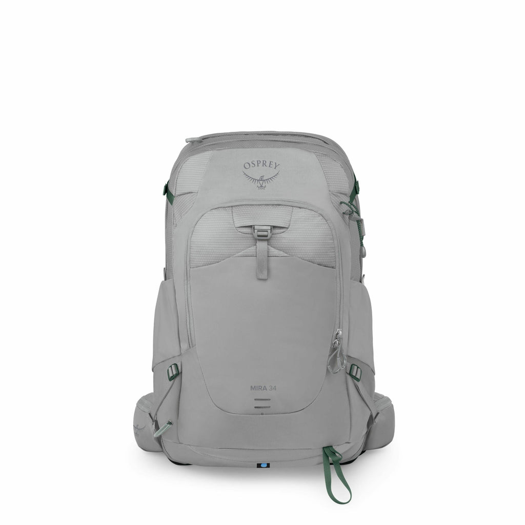 The image features an Osprey Mira 34 backpack, designed with a sleek and functional aesthetic. It is primarily a light gray color, complemented by green accents found on straps and zipper pulls. The backpack showcases a practical and modern design with mu