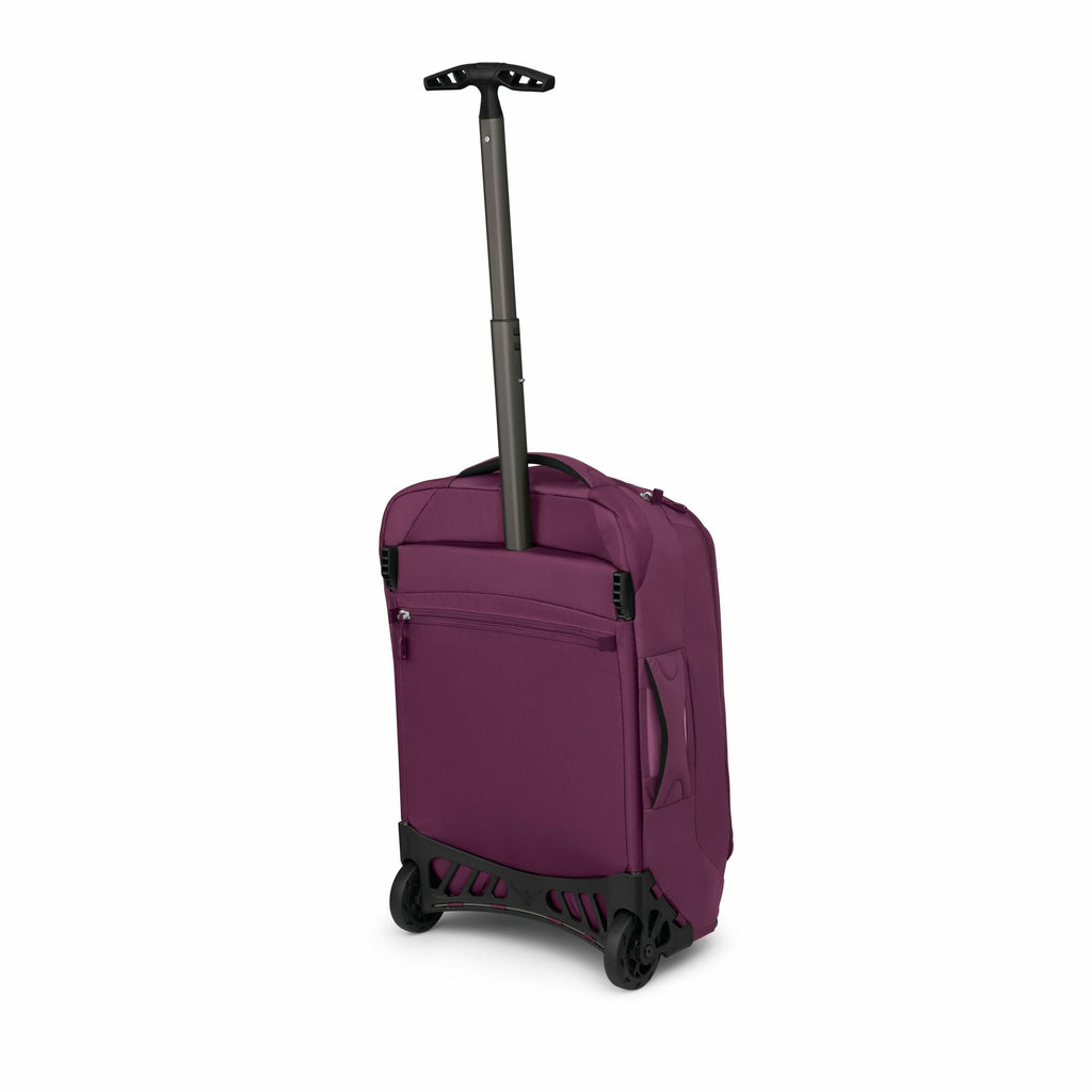 The image shows a burgundy-colored rolling suitcase with a retractable handle and a pair of wheels at the bottom. The suitcase is upright, displaying a zippered pocket on its front, indicating storage accessibility. The retractable handle is extended, sug