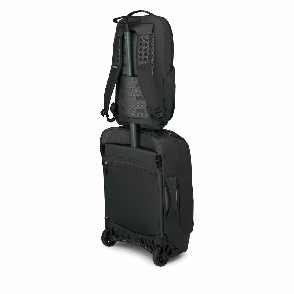 The image shows a black wheeled suitcase with a backpack attached to its extended handle, typical of travel luggage that offers dual functionality. The suitcase is designed with two large wheels for easy mobility, and a smooth, sleek exterior. The backpac