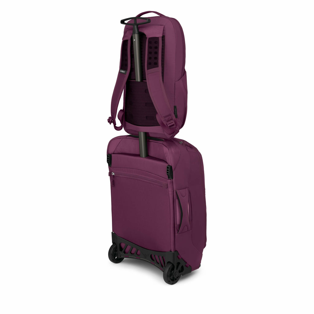 The image shows a luggage piece that appears to combine both a backpack and a rolling suitcase in a single unit, presented in a deep burgundy color. The suitcase has wheels and a retractable handle, indicating it can be easily rolled along. Attached to th