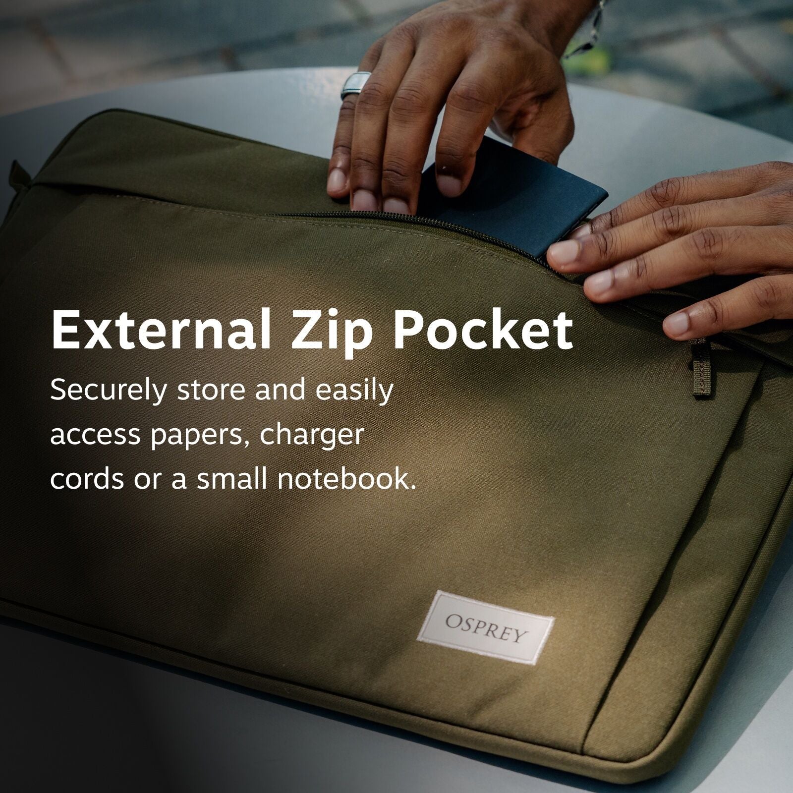 The image features a close-up view of someone placing a dark-colored item, possibly a charger or a notebook, into an olive-green bag with an external zip pocket. The bag is branded with an "OSPREY" label. The text overlay highlights the utility of the ext