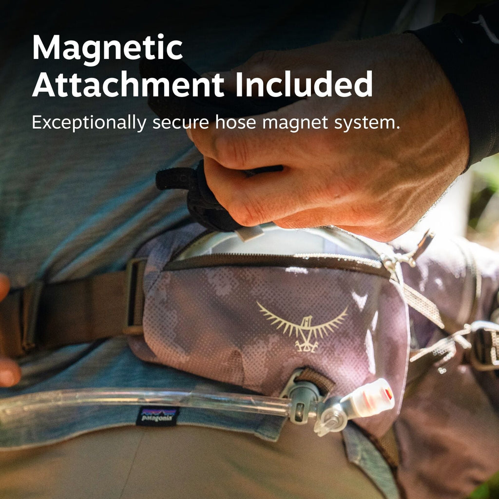 The image shows a person wearing a waist pack with an attached hydration system, indicated by the visible hose and mouthpiece. The text on the image reads "Magnetic Attachment Included" and "Exceptionally secure hose magnet system," suggesting that the hy