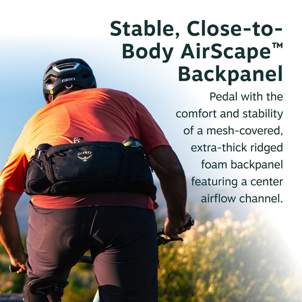 The image features a cyclist from behind, riding a bicycle along a trail surrounded by green bushes and grass. The cyclist is wearing a red shirt, black pants, and a helmet, and has an Osprey brand pack strapped around their lower back. The background sho