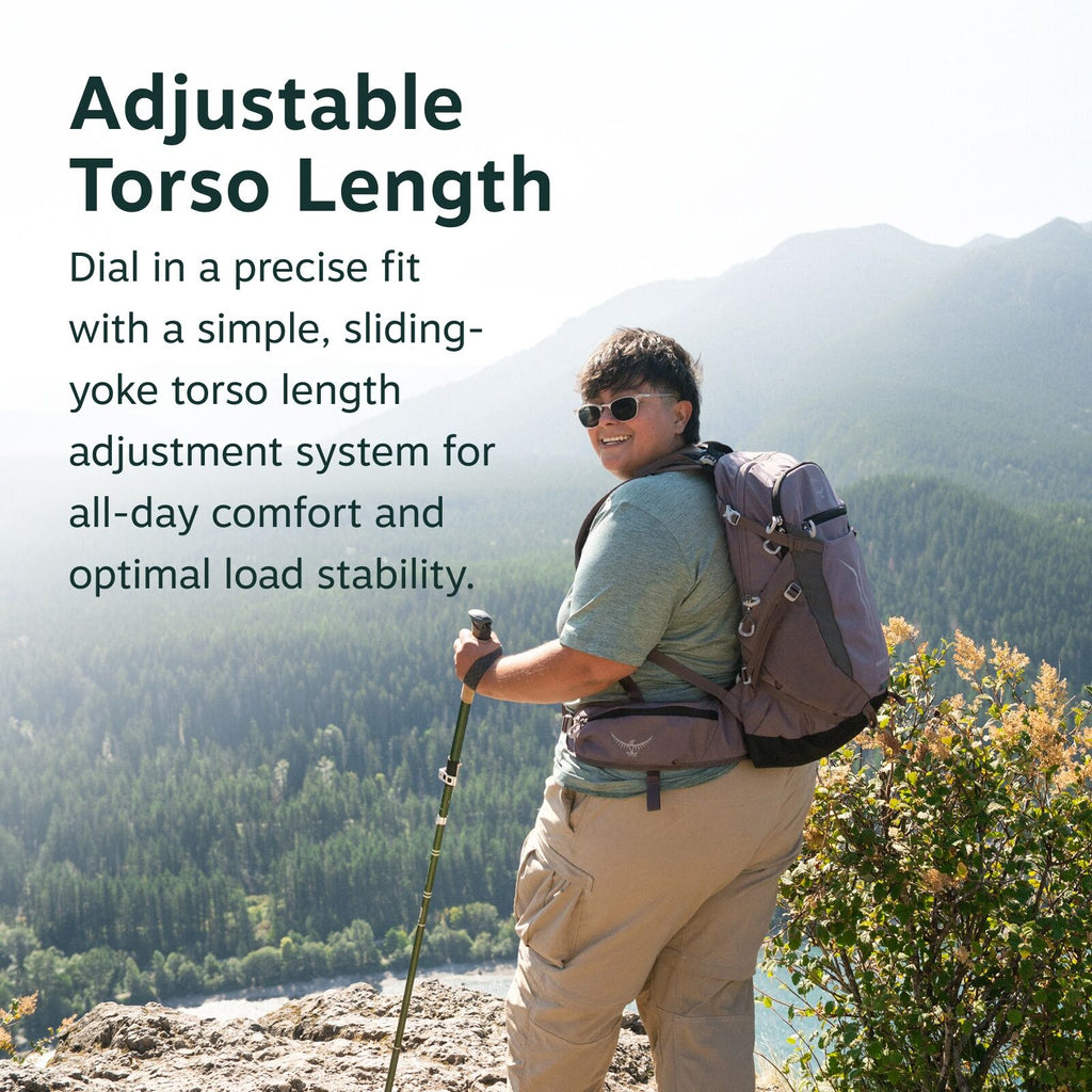 The image features a person standing on a rocky outcrop with a scenic mountain view in the background. They are wearing a light green shirt and khaki cargo pants, and carrying a large backpack. In their right hand, they hold a hiking pole. The accompanyin