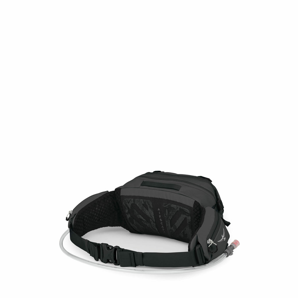 The image features a black waist pack designed for outdoor activities, such as hiking or running. The pack is equipped with a hydration system, evident from the hose extending from the side and a nozzle with a red tip. It has an adjustable waist strap wit