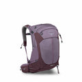 The image showcases a purple Osprey Sirrus 24 backpack, designed for hiking or outdoor adventures. The backpack features multiple compartments, including two zippered pockets on the top flap, a large central pocket, and additional side pockets for storage