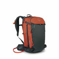 The image shows an Osprey backpack with a combination of dark gray and orange colors. The main body of the backpack is predominantly dark gray, while the top section and the zipper accents are a bright orange. The backpack has a robust design, featuring p