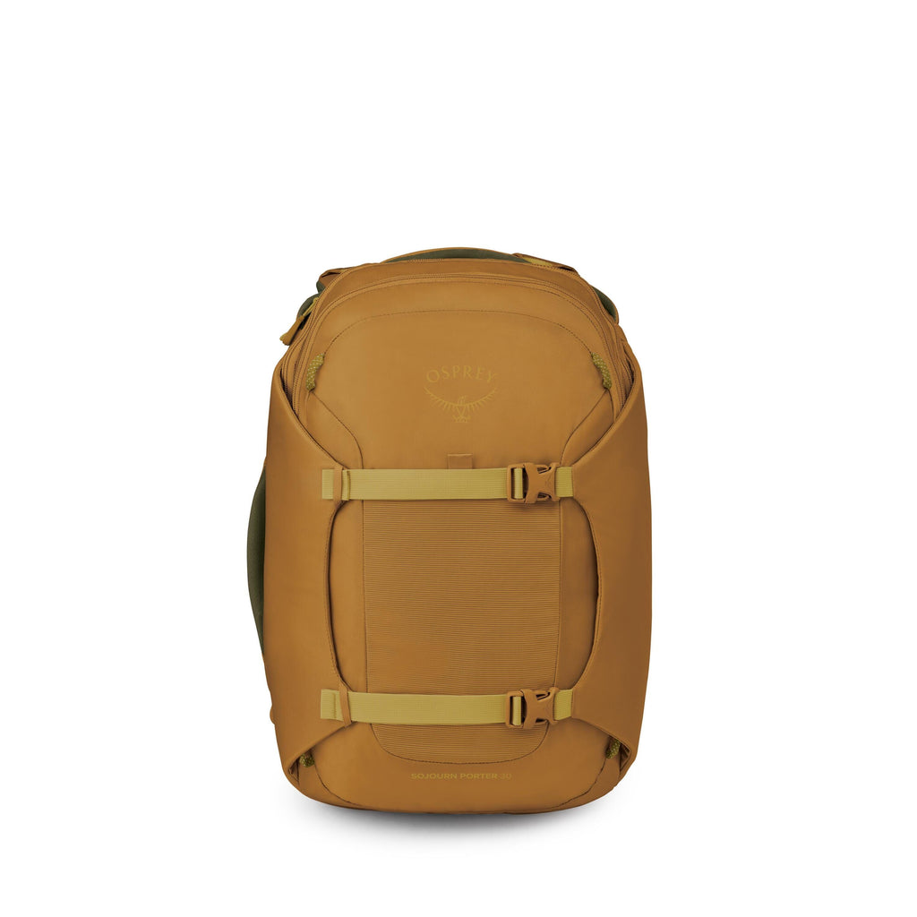 A tan-brown Osprey backpack is centered against a white background. The pack has a streamlined, rectangular shape with rounded edges and two light-olive compression straps across the front secured by buckles. A small top pocket and a larger front panel ar