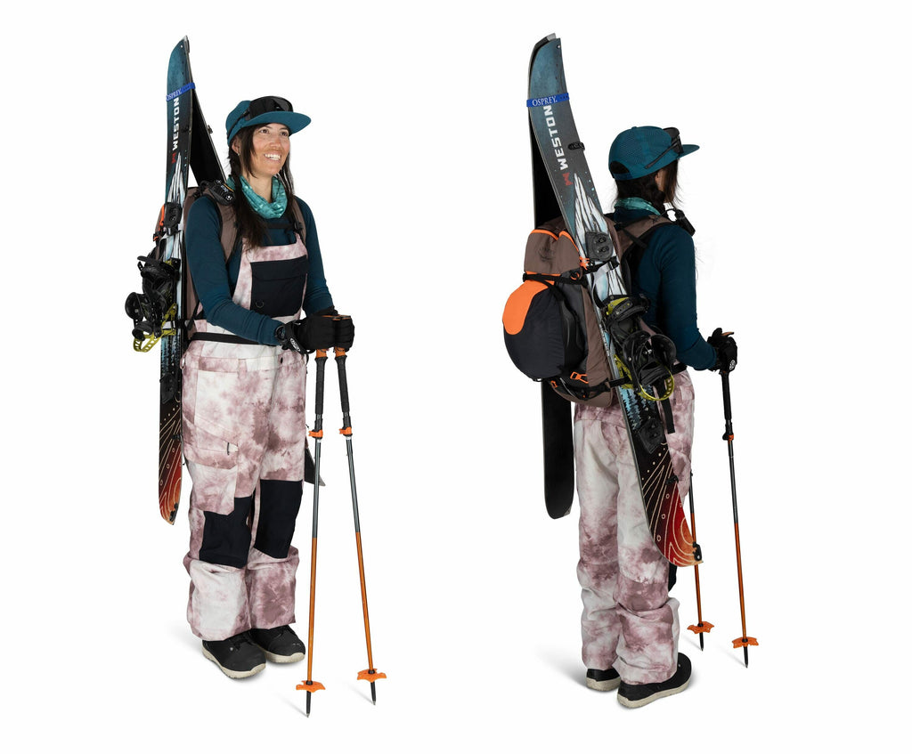 The image shows a person dressed in winter gear, likely prepared for skiing or snowboarding. They are wearing a blue long-sleeve shirt under a pair of pinkish-white patterned snow overalls, and their outfit includes blue gloves and a teal cap. The individ