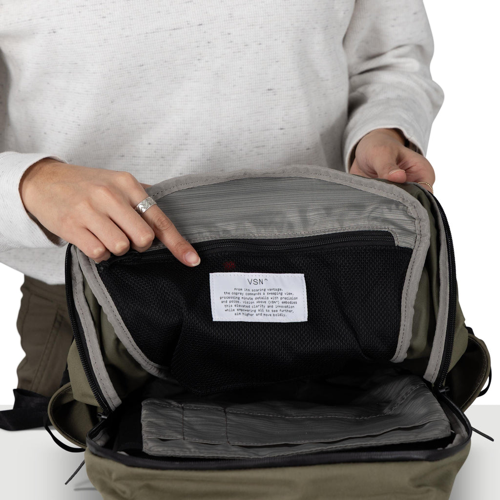 A person wearing a green plaid flannel shirt is holding a brown backpack and displaying a black and white panel that describes the VSN product's elevated and innovative design.