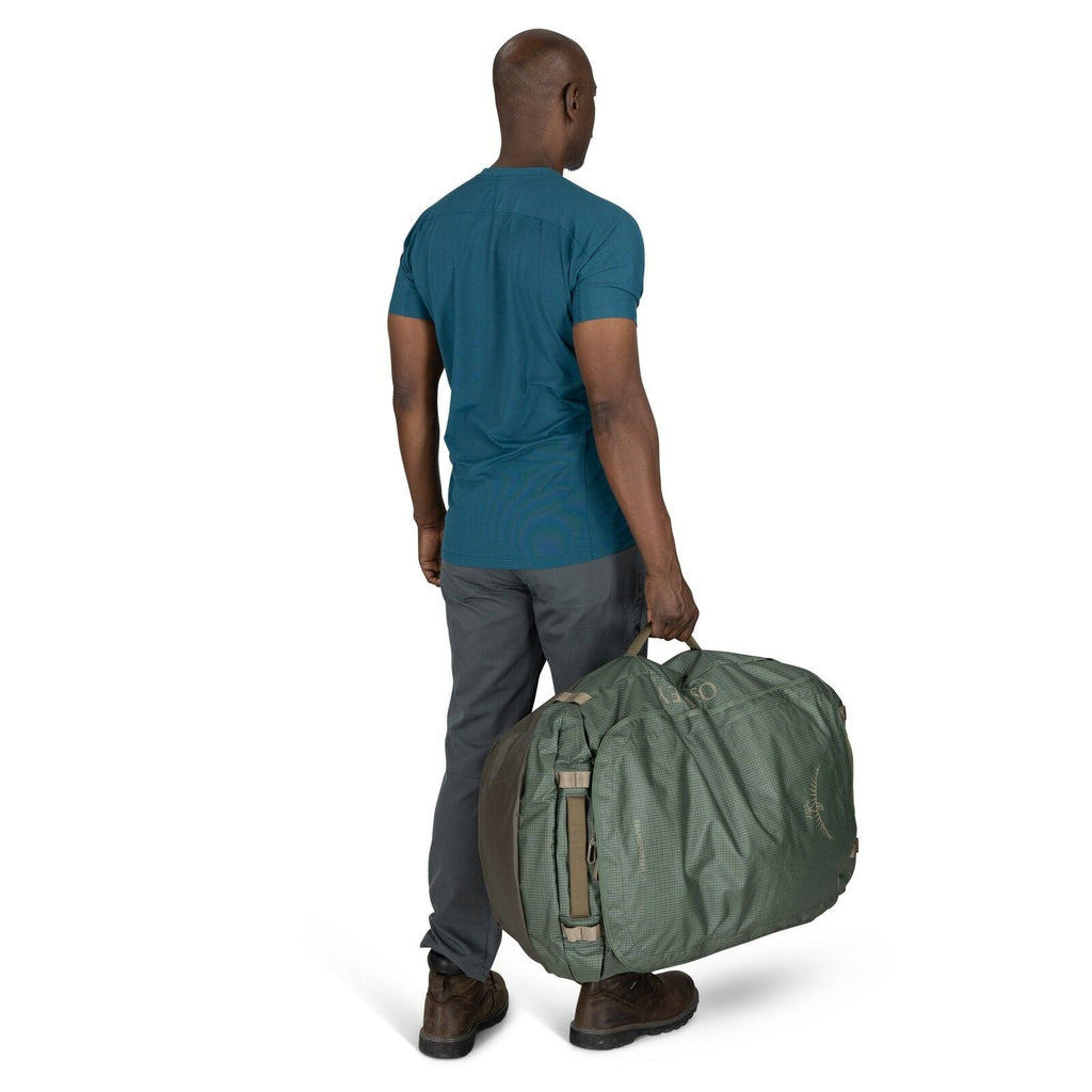 Image of model holding the Transporter Duffel 95 in the color Pine Leaf / Earl Grey