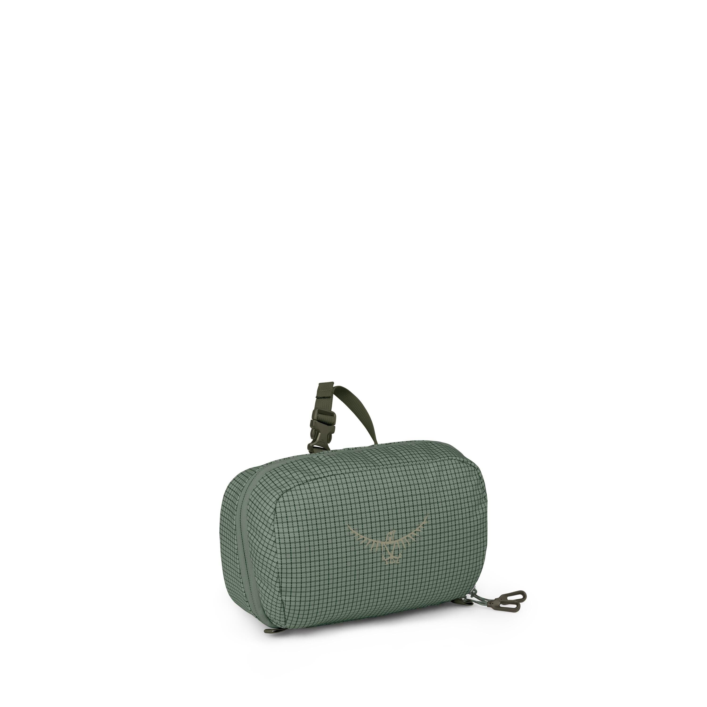 A small green travel pouch is shown from multiple angles against a white background. The bag has a subtle grid pattern, rounded edges, and a compact rectangular shape. It features dual zippers, a small top strap with a buckle, and a detachable clip seen s