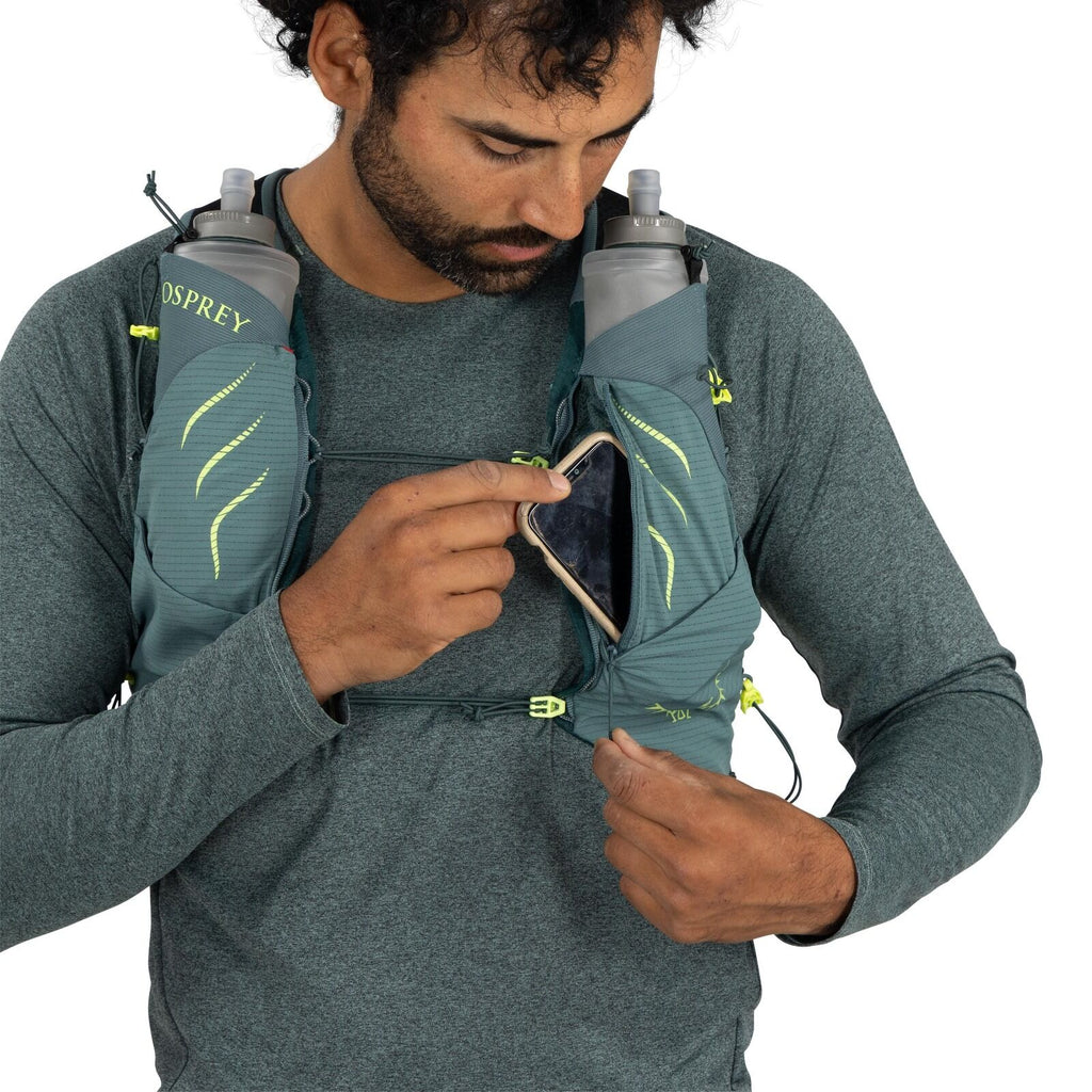 The image shows a person wearing a running vest, specifically designed for carrying water bottles and small essentials. The vest is made by Osprey, as indicated by the brand logo visible on one of the bottle holders. Two large bottles are secured in the v