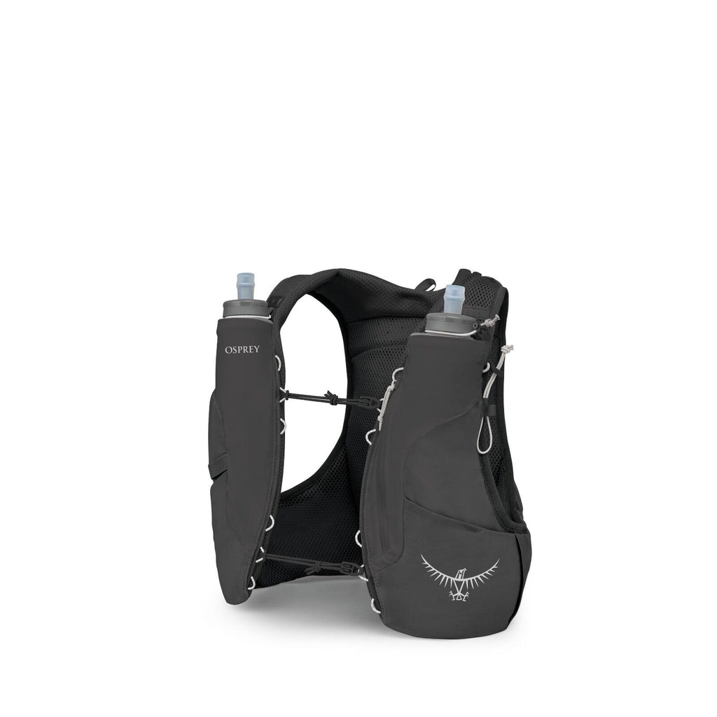 The image shows a person wearing a teal long-sleeve athletic shirt and dark shorts, equipped with a light hiking or running vest. The vest, which is light blue in color, is equipped with various gear including a trekking pole and a water bottle, indicatin