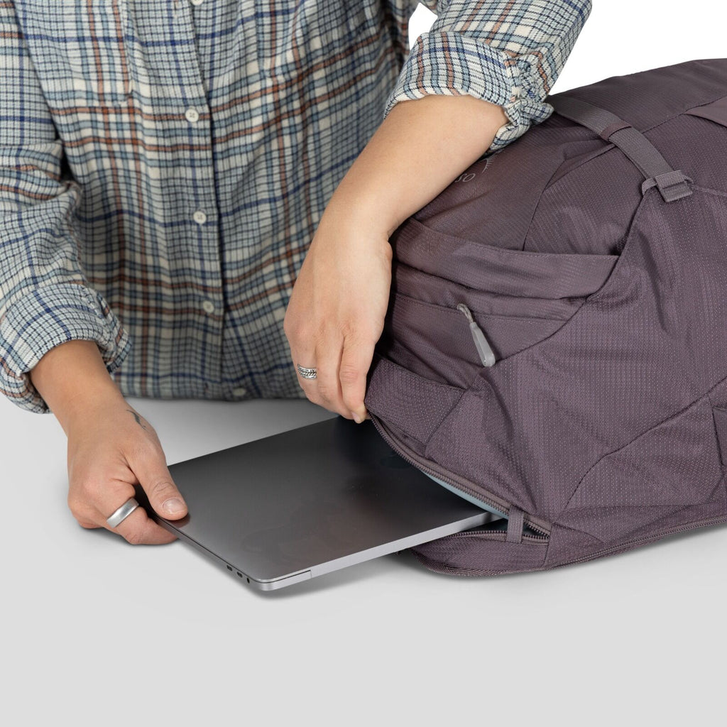 A model showing detailed images of the Fairview 40 Travel pack in the color Graphite Purple.