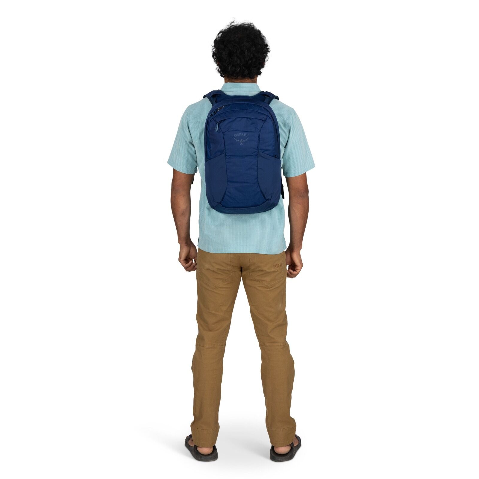 Model wearing the Osprey Farpoint 70 Travel pack in the color Antique Blue
