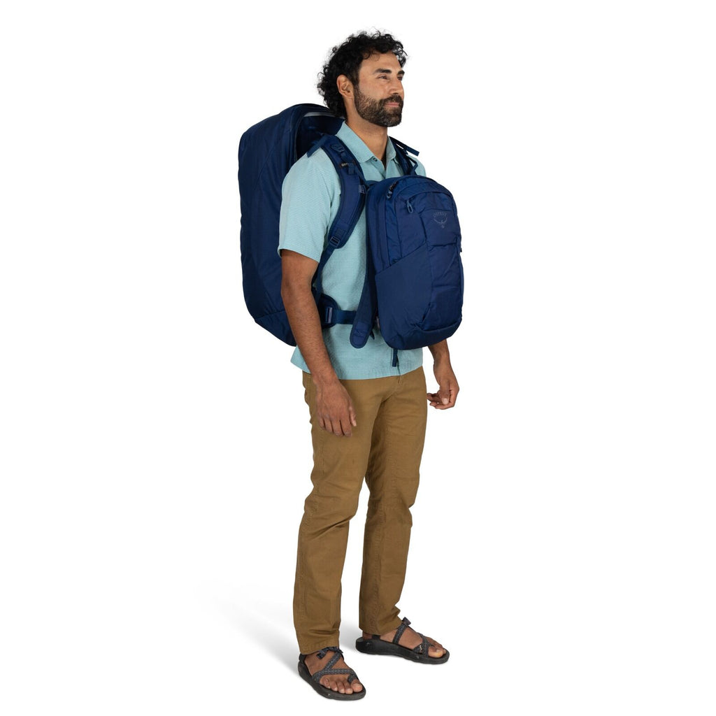 Model wearing the Osprey Farpoint 70 Travel pack in the color Antique Blue