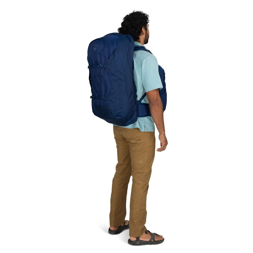Model wearing the Osprey Farpoint 70 Travel pack in the color Antique Blue