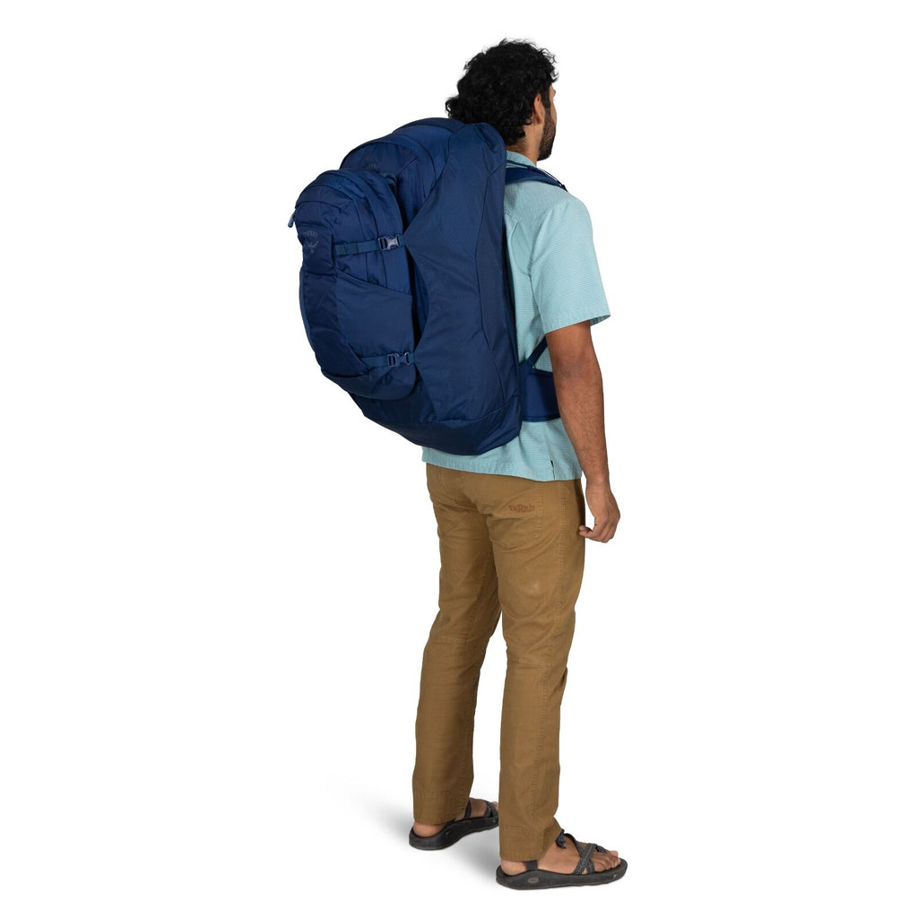 Model wearing the Osprey Farpoint 70 Travel pack in the color Antique Blue