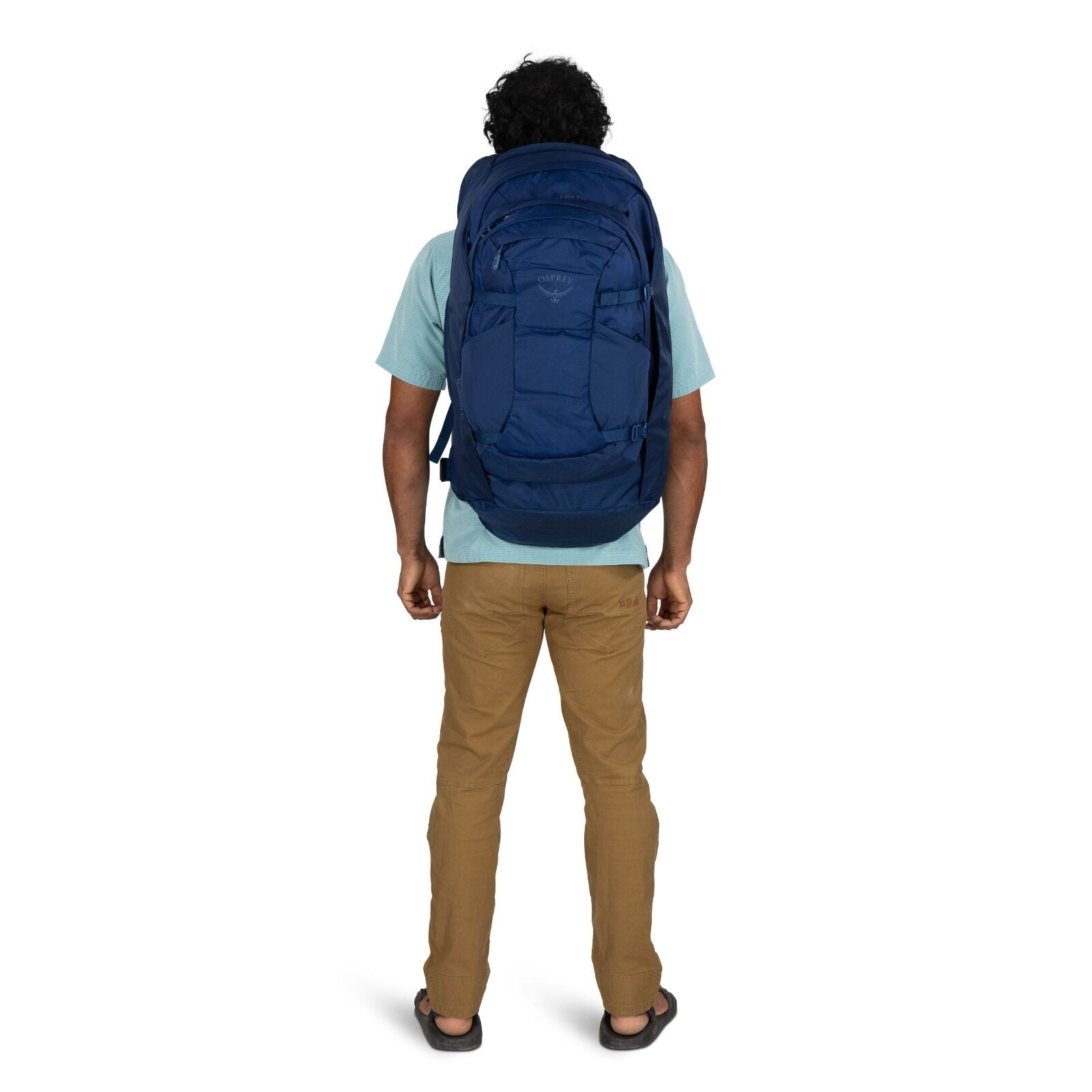 Model wearing the Osprey Farpoint 70 Travel pack in the color Antique Blue