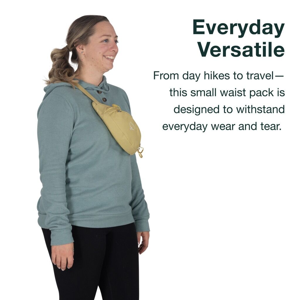 Woman wearing a teal sweatshirt and black leggings with a small, light-yellow Osprey waist pack.