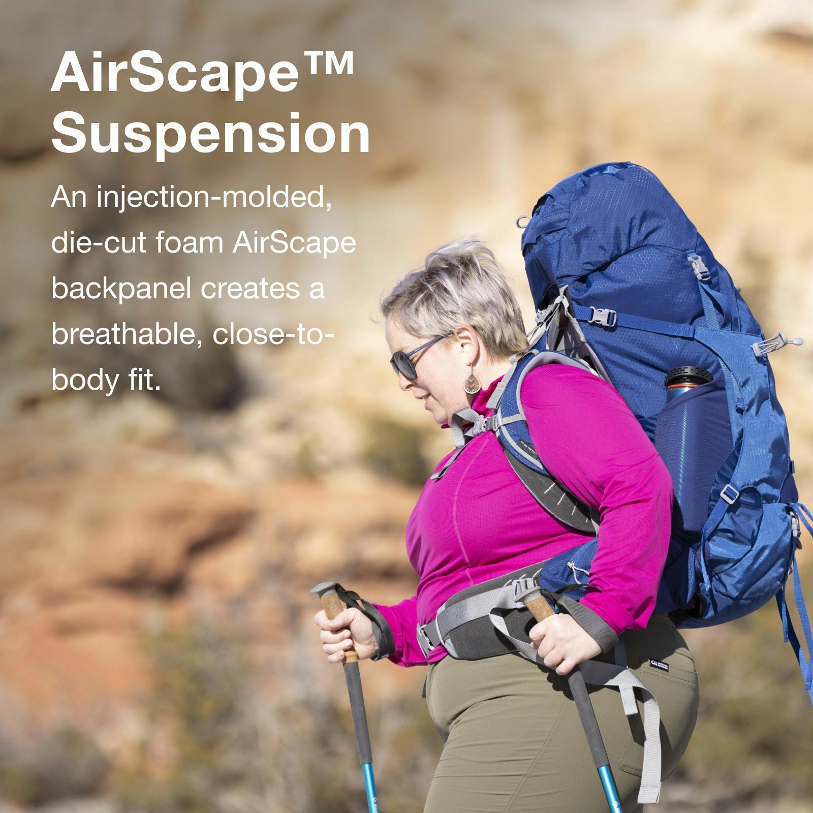 A hiker wears a large blue backpack with a water bottle, showcasing the AirScape™ Suspension for comfort and breathability in an outdoor setting.