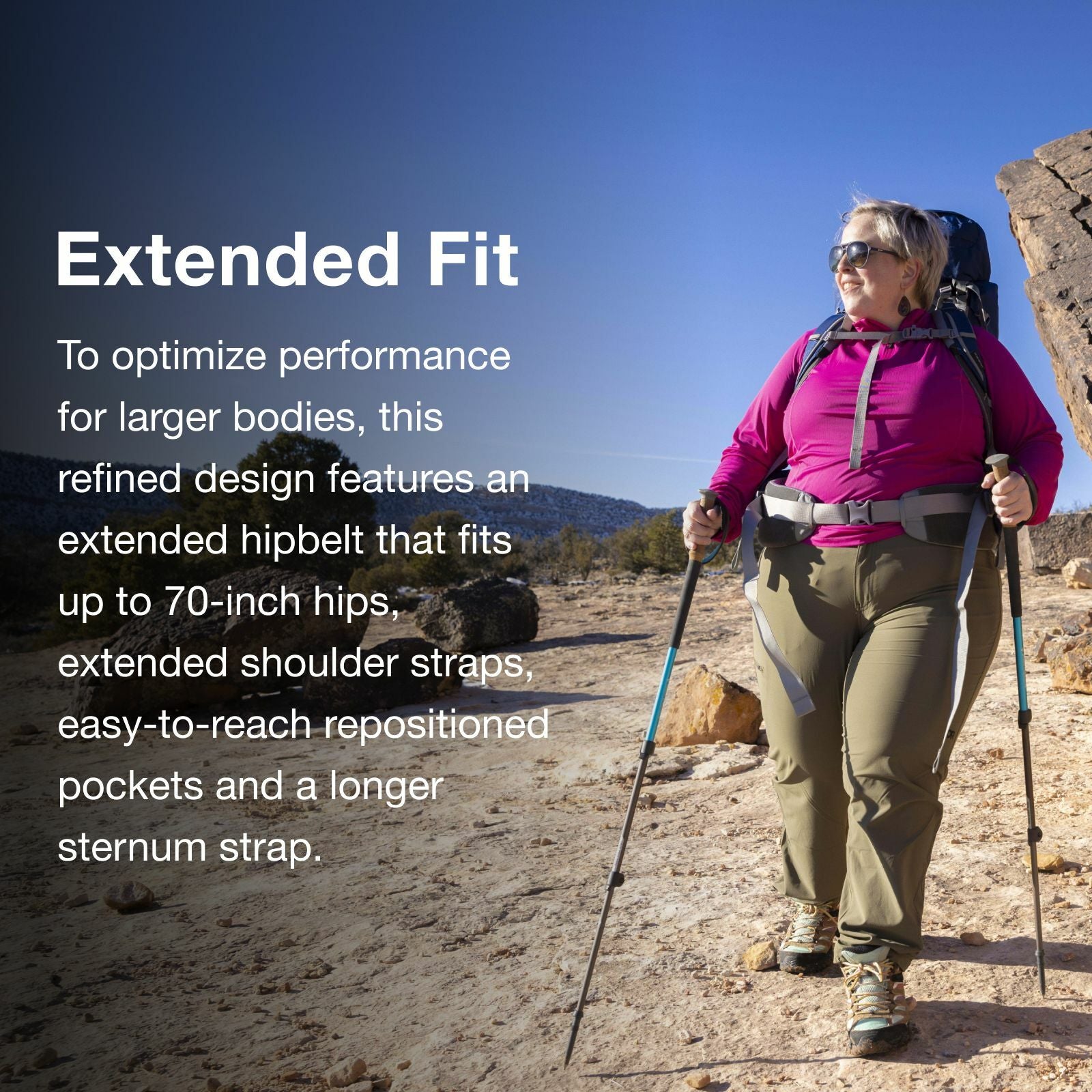 A hiker walks outdoors on rocky terrain, showcasing a backpack designed for larger bodies with an extended hipbelt and shoulder straps.