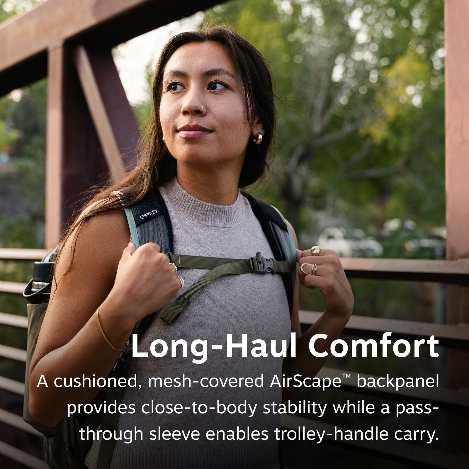 A woman wearing a backpack stands on a bridge, looking into the distance thoughtfully. Text below reads: "Long-Haul Comfort." The setting is serene.