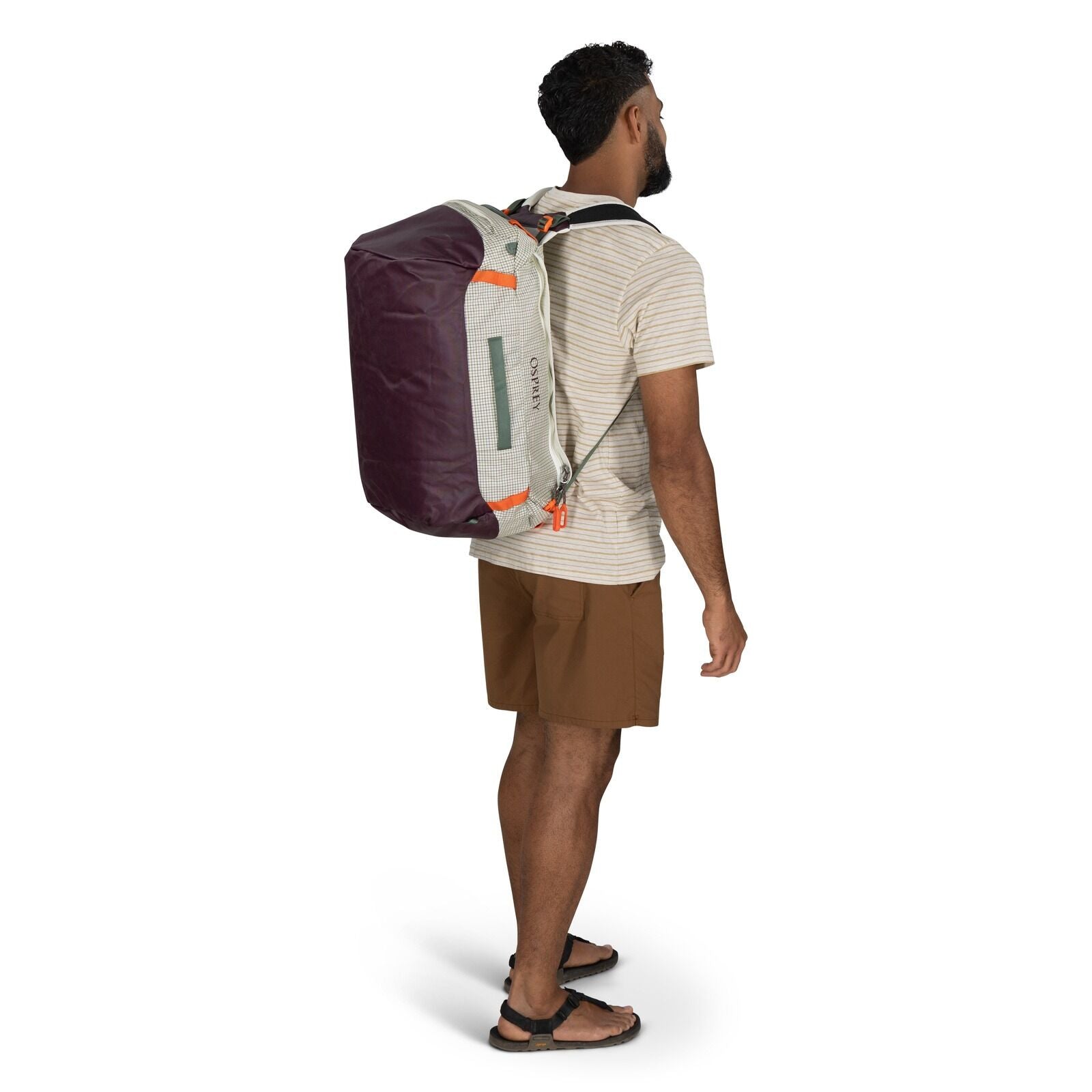 The image features a person standing and wearing a duffel bag.