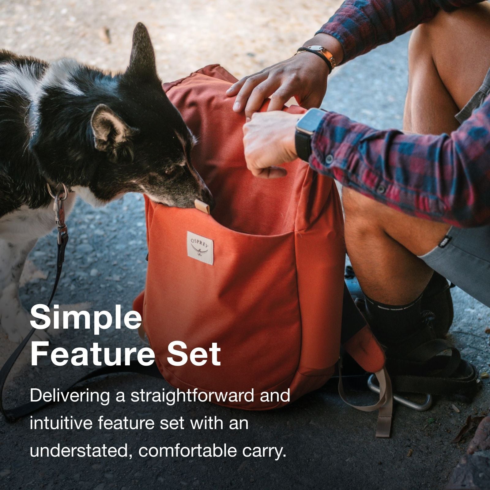 A person crouches next to a brown dog, interacting with a red backpack labeled "OSPREY," emphasizing simple, intuitive design.